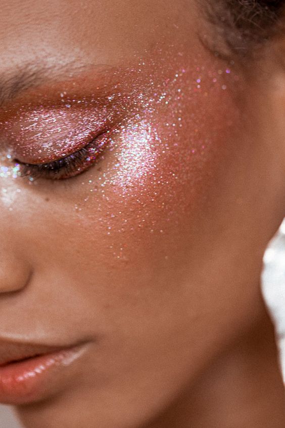 Model using glitter gel on her cheekbones