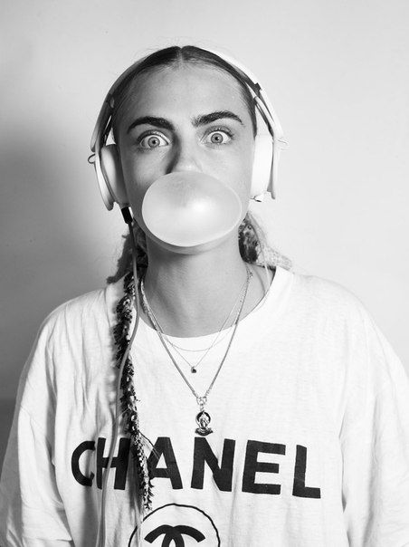 Model showing off great eyebrows while wearing a headset and blowing a chewing gum bubble