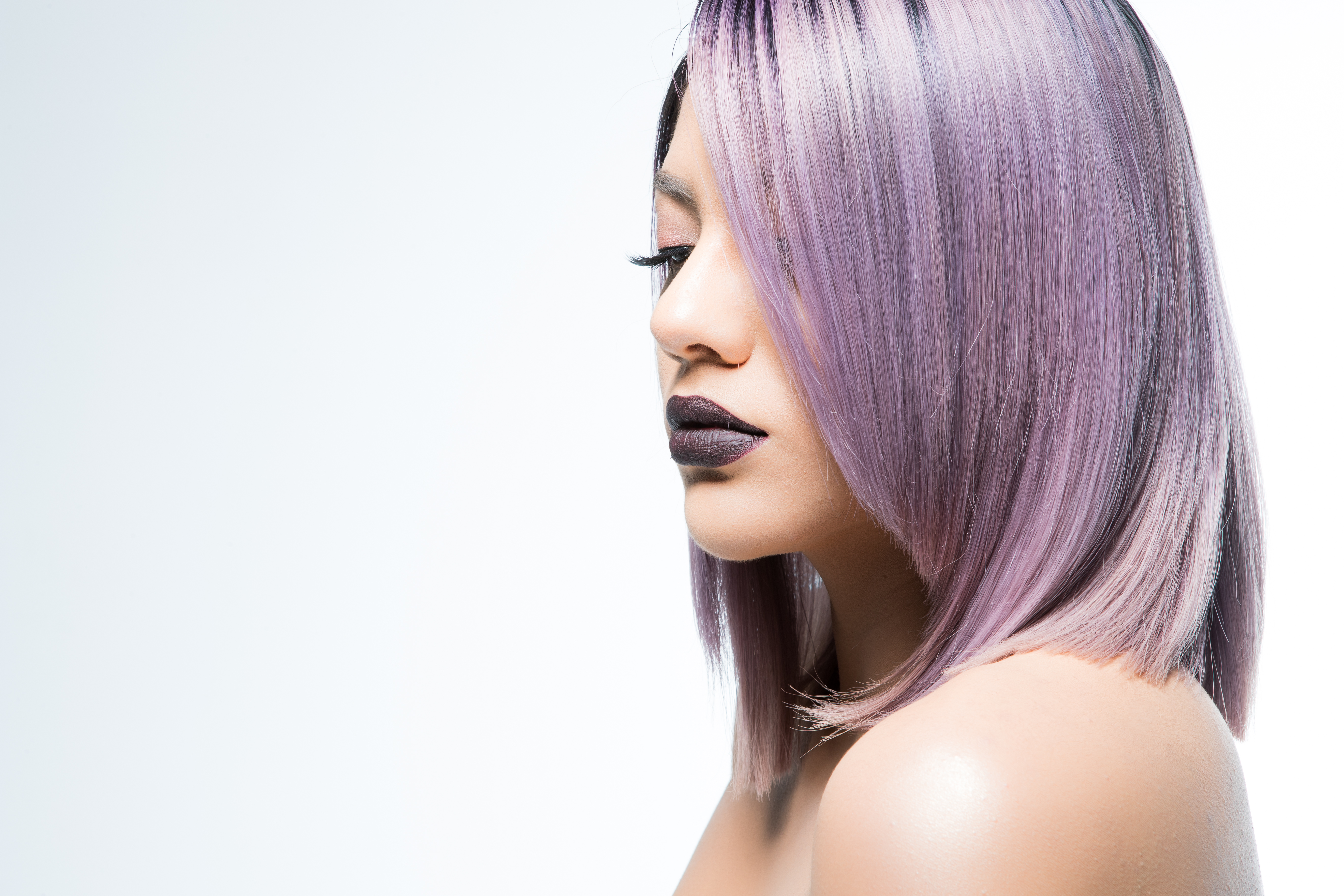 Side-profile of a model with pastel-lilac bob and a smokey lilac lipstick
