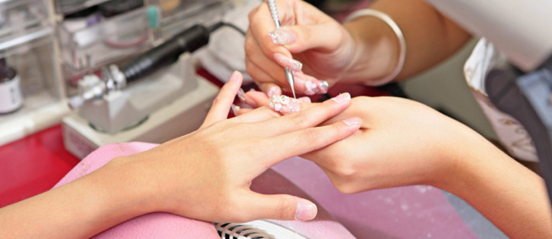 Nail Tech giving a client a manicure. Learn more about Federico's Manicuring program today.